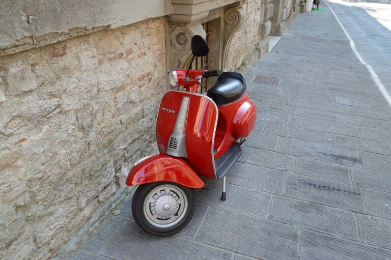 Scooter Vespa rouge garé dans une rue